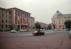 Romania,Transylvania, Cluj-Napoca, Piața Lucian Blaga, balra a Diákok Művelődési Háza, jobbra a Kolozsvári Egyetemi Könyvtár épülete., 1975, Fortepan, colorful, flag, Dacia-brand, political decoration, Nicolae Ceaușescu-portrayal, Fortepan #21432