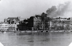 Magyarország, Budapest V., balra az Eötvös tér, mögötte az Apáczai Csere János (Mária Valéria) utca házai, jobbra a Dunakorzó. Szemben a Dunapalota / Ritz szálló, 1945. január 15-én bombatalálattól lángra kapott és több napon át lobogva, teljesen kiégett épülete., 1945, Vörös Hadsereg, füst, tűz, Budapest, épületkár, Fortepan #217677