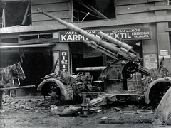 Magyarország, Budapest II., a felvétel a Fő utca 51-es számú ház előtt készült., 1945, Vörös Hadsereg, ló, járműroncs, üzletportál, löveg, kárpitos, Budapest, légvédelmi ágyú, Fortepan #217745