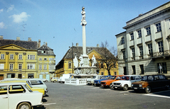 Magyarország, Győr, Széchenyi tér, középen a Stelczer Lajos utca sarkán a Vastuskós ház és a Xantus János Múzeum (Apátúr ház). Előtérben a Mária oszlop Buda 1686. évi visszafoglalásának emlékére, ettől jobbra a Rába Városi Művelődési Központ (egykori Lloyd székház, ma irodaház)., 1985, Dőri András, színes, Fortepan #218732