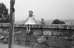 Magyarország, budai Vár, Budapest I., mellvéd a mai Mátyás király játszótér környékén., 1963, László Áron, Budapest, falon ülni, fehér ruha, játék baba, kislány, korláton ülni, Fortepan #219481