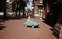 Magyarország, Budapest VI., Andrássy út (Népköztársaság útja), a felvétel 45. számú ház, az Írók boltja előtt készült. Jobbra a Liszt Ferenc tér, távolabb balra az Oktogon (November 7. tér)., 1969, N. Kósa Judit, pedálos autó, Budapest, Fortepan #219986