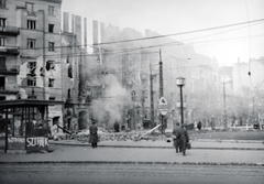 Magyarország, Budapest XI., Móricz Zsigmond körtér, háttérben a megrongálódott 2-es számú ház, jobbra a Bartók Béla út., 1956, Matthaeidesz Konrád, Budapest, forradalom, épületkár, köztéri óra, felirat, Fortepan #221638