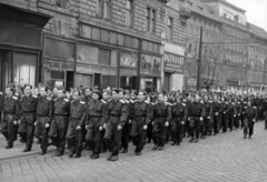 Magyarország, Budapest VIII., Baross tér, repülőiskola növendékek a május 1-i felvonuláson a 6. és a 4-5. számú ház előtt, jobbról az 1., 2. és 3. számú ház. A kettő között balra kezdődik a Fiumei út., 1953, Nasztanovics Ferenc, Budapest, cégtábla, fiatalság, egyenruha, felvonulás, repülés, május 1, Fortepan #222091