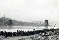 Hungary, Budapest V., pesti alsó rakpart, dunai átkelésre váró budapestiek sora, háttérben a lerombolt Széchenyi Lánchíd., 1945, Kádár Anna, mass, wrecked bridge, picture, standing in line, Budapest, Fortepan #223884