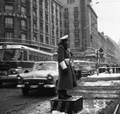 Magyarország, Budapest VII., Rákóczi út az Astoria kereszteződésből nézve., 1966, Magyar Rendőr, közlekedés, tél, hó, forgalom, szovjet gyártmány, GAZ-márka, magyar gyártmány, utcakép, rendőr, aluljáró, Ikarus 60 csuklós, Ikarus 620/630, villamosmegálló, automobil, GAZ M21 Volga, rendőrdobogó, neon felirat, Budapest, forgalomirányítás, Fortepan #22596