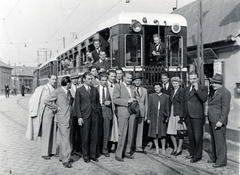 Magyarország, Budapest XXII., Nagytétényi út (Vörös hadsereg útja) a Szabadság utca irányából a város felé nézve, a Móricz Zsigmond körtérről induló HÉV-vonal végállomása., 1946, Fóris Gábor / Vastagh Miklós hagyatéka, Budapest, sínpálya, öltöny, úriember, hölgy, csoportkép, cigaretta, kalap, ballonkabát, cégtábla, felsővezeték, Fortepan #226344