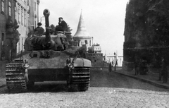 Magyarország, budai Vár, Budapest I., Szentháromság tér, a Pénzügyminisztérium (egykori jezsuita kollégium, ma a Hilton szálló van a helyén) épülte előtt egy Panzerkampfwagen VI Ausf. B német nehézharckocsi áll. Jobbra a Mátyás-templom, háttérben a Halászbástya., 1944, Fortepan/Album076, Panzerkampfwagen VI B, harckocsi, Budapest, Fortepan #227097