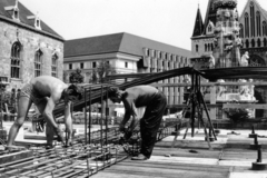 Magyarország, budai Vár, Budapest I., Szentháromság tér, a Diplomata-ház építkezése a Szentháromság utca sarkán. Háttérben a BME Schönherz Zoltán Kollégiuma (az egykori Pénzügyminisztérium épülete), a Hilton szálló és a Mátyás-templom., 1980, Középületépítő Vállalat - Kreszán Albert - Koczka András - Kemecsei József, Budapest, vasalás, Fortepan #227157