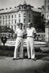 Magyarország, Budapest VIII., Rákóczi tér a József körút felé nézve, a háttérben a Békési (Békés) utca torkolata. A két férfi mögött a Négy évszak szökőkút csonkán (csak a medence és a kút talapzata látszik)., 1935, Vízkelety László, Budapest, Fortepan #227543