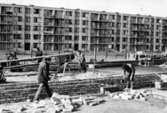 Magyarország, Budapest XVIII., Szent Lőrinc lakótelep (KISZ lakótelep), a Margó Tivadar (Rákóczi) utca 77. alatt álló FEAL-rendszerű, 8 tantermes, könnyűszerkezetes iskola építése, háttérben a Kele utca 1-11 számú ház., 1971, Középületépítő Vállalat - Kreszán Albert - Koczka András - Kemecsei József, Budapest, Fortepan #228071