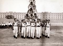 Magyarország, Budapest XI., Kőrösy József (Mező) utca, BEAC sportpálya, háttérben a Lágymányosi dohánygyár épülete., 1928, Hirsch Hugó, sportpálya, Lágymányos, dohánygyár, mutatvány, emberi piramis, Budapest, Fortepan #229357