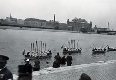 Hungary, Budapest XI.,Budapest IX., budai alsó rakpart a Műegyetem előtt, a Hitlerjugend westfáliai tengerészalakulatának fogadása a Duna-parton. A túlparton jobbra az Elevátorház és a Petőfi (Horthy Miklós) híd pesti hídfője., 1940, Bor Dezső, Best of, boat, paddling, shore, festive, wharf, river guard, swastica, gesture, sailor dress, paddle, Budapest, Fortepan #231571