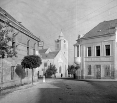 Magyarország, Vasvár, Március 15. tér a Szentmihályfalvi utca felől. Háttérben a domonkos templom, balra a Zöldfa étterem, jobbra a Korona szálló., 1952, Építész, templom, utcakép, szálloda, étterem, távközlés, kilométerkő, dominikánus rend, Fortepan #23456