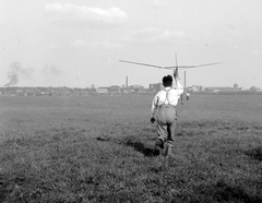 Magyarország, Budapest XXI., Csepel, a Weiss Manfréd Művek repülőtere, háttérben jobbra a Soroksári úti épületek látszanak. A repülőgépgyár modellezőinek versenyéről Korbuly László gyárigazgató készítette a felvételt., 1939, Korbuly, repülőgépmodell, Budapest, Fortepan #2389