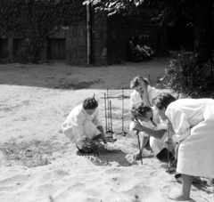 Magyarország, Budapest XIV., Thököly út 48., a Petrik Lajos Vegyipari Technikum udvara, diákok öntöttvas eszközöket tisztítanak homokkal., 1958, Ungváry Rudolf, Budapest, képarány: négyzetes, munkaköpeny, vidámság, nők, Fortepan #254829