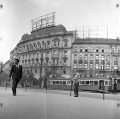 Magyarország, Budapest XIII., Nyugati (Marx) tér, szemben az 5-ös és 4-es számú ház., 1957, Ungváry Rudolf, Best of, Budapest, villamos, hajviselet, képarány: négyzetes, korlát, zsebredugott kéz, kockás ing, híres ember, épületszobor, aktatáska, Fortepan #254866