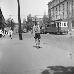 Magyarország, Budapest VI., Teréz (Lenin) körút - Podmaniczky (Rudas László) utca kereszteződése, háttérben a Nyugati pályaudvar és a 62-es posta., 1957, Ungváry Rudolf, Budapest, villamos, képarány: négyzetes, fiatalság, híres ember, rendőrkalitka, Fortepan #254875