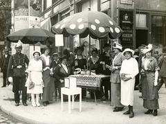 Magyarország, Budapest V., Kossuth Lajos utca - Károly körút sarok. Ferenc József születésnapja alkalmával tartott "katona-nap", adománygyűjtés a hadbavonult katonák családjai javára., 1914, Országos Széchényi Könyvtár, Müllner János, Budapest, bank, napernyő, nők, Ferenc József ábrázolás, rendőr, doboz, persely, Fortepan #256142