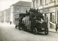 Magyarország, Budapest VII., Dohány utca - Rózsa utca sarok, háttérben a Rózsák tere (Szegényház tér) 1., Protestáns árvaház (később Evangélikus Középiskolai Kollégium) épülete. Előtérben egy katonai teherautó (tábori mosókonyha)., 1916, Országos Széchényi Könyvtár, Müllner János, Budapest, rendszám, teherautó, üzletportál, zászló, Fortepan #256184