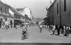 Romania,Transylvania, Cluj-Napoca, Wesselényi Miklós utca (Strada Regele Ferdinand, ekkor Strada Dózsa György) a Fő tér felől, jobbra az evangélikus templom., 1958, Közösségi Szociális Szövetkezet, street view, public clock, pedestrian, bicycle, Fortepan #256544