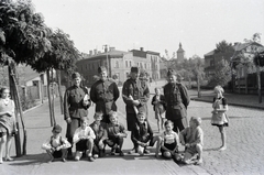 Lengyelország, Ruda Śląska, Kochłowice (ekkor Kochlowitz) ekkor önálló, ma a város része. Ulica Oświęcimska, balra a háttérben az ulica Radoszowska, jobbra a háttérben a Tűzoltóság tornya az ulica Solna-ban, jobb szélen az ulica Oświęcimska 123., 1942, Reményi József, fiúk, katona, guggolás, Fortepan #257671