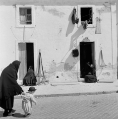 Portugália, Nazaré, 1959, UWM Libraries, Eugene Vernon Harris, ruhaszárító, idős ember, unoka, vállkendő, leselkedő, Fortepan #260605