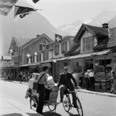 Svájc, Grindelwald, Dorfstrasse., 1958, UWM Libraries, Eugene Vernon Harris, képarány: négyzetes, beszélgetés, kézikocsi, kerékpár, postás, teherhordás, vöröskereszt, üzletsor, Fortepan #260662