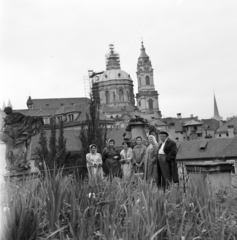 Czech Republik, Prague, Vrtbovská park, balra a szobor Matyáš Bernard Braun alkotása. Háttérben a Szent Miklós-templom., 1961, Faragó György, tableau, raincoat, steeple, sculpture, Czechoslovakia, Fortepan #260923