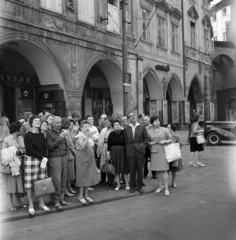 Czech Republik, Prague, a turisták az Óváros téren (Staromestske namesti) állnak és
az Orjol-t, a prágai városháza oldalán található óraművet nézik. Jobbra a Melantrichova ulice torkolata., 1961, Faragó György, gaping, archway, checked dress, handbag, Czechoslovakia, Fortepan #260934