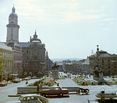 Magyarország, Pécs, Széchenyi tér, kilátás a Dzsámi felől. Balra a Városháza tornyos épülete, középen Hunyadi János szobra, jobbra a Szentháromság-szobor., 1965, Faragó György, motorkerékpár, színes, automobil, Opel-márka, lovas szobor, szentháromság szobor, parkoló, Fortepan #260979