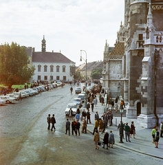 Magyarország, budai Vár, Budapest I., Szentháromság tér a Halászbástyáról nézva. Szemben a Tárnok utca - Szentháromság utca sarkán a régi budai Városháza, jobbra a Mátyás-templom., 1969, Faragó György, Budapest, parkoló, színes, Fortepan #261156