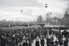 Hungary, Budapest XIV., Műjégpálya, háttérben a Városligeti-tó feletti híd és a millenniumi kiállításra készült Székesfővárosi pavilon., 1955, Faragó György, gaping, skating, Budapest, Fortepan #261693