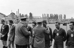 Magyarország, Budapest XIX.,Budapest XVIII., a Budapesti Honvéd SE pályája, háttérben a Lőrinci Hengermű., 1958, Faragó György, Budapest, hátratett kéz, címer, sport mez, háttal, katona, díjkiosztó, Fortepan #261804