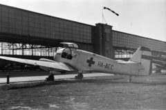 Magyarország, Budaörsi repülőtér, Budapest XI., Aero Ae-45 típusú repülőgép a hangár előtt., 1958, Faragó György, Aero Ae45, repülőtér, hangár, Budapest, szélzsák, repülőgép, lajstromjel, vöröskereszt, Fortepan #261867