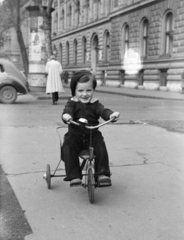 Magyarország, Budapest VI., Andrássy út (Népköztársaság útja), a felvétel az Izabella utcánál készült, jobbra a 73-75. számú épület a MÁV Igazgatósága., 1953, Gyulai Gaál Krisztián, hirdetőoszlop, tricikli, gyerek, Budapest, gyerektricikli, Fortepan #262208