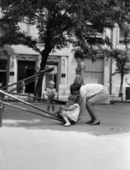 Magyarország, Budapest XIII., Jászai Mari tér, játszótér, a háttérben az 5. szám alatti Palatinus-ház., 1970, Gyulai Gaál Krisztián, Budapest, segítség, anya, kislány, libikóka, Fortepan #262407