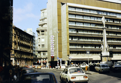 Magyarország, Budapest V., Szervita (Martinelli) tér, Mária oszlop, háttérben az Országos Műszaki Fejlesztési Bizottság (OMFB) székháza. Balra a Kristóf tér és a Bécsi utca., 1988, Lorkó Fanni, Skoda-márka, színes, rendszám, szobor, oszlop, Skoda 105/120, autókereskedés, Budapest, Fortepan #263273