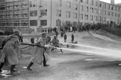 Magyarország, Budapest XI., a Sopron út - Hauszmann Alajos (Bártfai) utca kereszteződése, tűzoltási gyakorlat, háttérben a Standard Villamossági Rt. (később BHG, Beloiannisz Híradástechnikai Gyár, majd BHG Hiradástechnikai Vállalat)., 1942, Horváth József, tűzoltó, tűzoltó fecskendő, gyakorlás, Budapest, rohamsisak, locsolás, Fortepan #265067