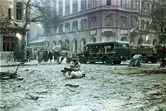 Magyarország, Budapest IX., Ferenc körút, operatőr munkában a Tompa utca torkolatánál. Háttérben egy Csepel D-350 rendőrségi riadókocsi roncsa., 1956, Horváth József, Best of, filmkamera, járműroncs, színes, kalap, operatőr, forradalom, Csepel B-350/D-350, Csepel-márka, Csepel D-352, Budapest, Fortepan #265790