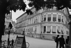 Ausztria, Bad Ischl, a felvétel a Traun Brücke hídfőjénél készült, szemben a Pfarrgasse és Stadtpfarrkirche St. Nikolaus tornya látható., 1937, Horváth József, sarokház, szálloda, plakát, Fortepan #266087