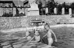 Hungary, Budapest XI., a felvétel a Villányi út 55-65. szám alatti 181 lakásos mintalakótelep parkjában készült, amelyet az építésügyi tisztviselők számára alakítottak ki 1954-ben. A medence parján a Brigádvezető nő szobrának részlete és talapzata látható, Oláh Sándor szobrászművész alkotása (1954)., 1955, Ábrahám Katalin és László, Budapest, height chart, splashing, kids, three people, Fortepan #266544