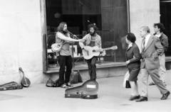 Magyarország, Budapest V., Váci utca - Vörösmarty tér saroképülete, utcazenészek az Óra és Ékszer üzlet előtt., 1985, Glósz András, gitár, hangszer tok, hangszer, furulya, szájharmónika, utcazene, Budapest, Fortepan #268377