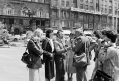 Magyarország, Budapest V., Vörösmarty tér, balról a második, Erdős Mariann, aki egynapos kimenőt kapott a Rákospalotai Lánynevelő Intézettől. Regős István a film készítője a stábbal beszélget. A felvétel a Bűn című négyrészes televíziós dokumentumfilm-sorozat forgatásakor készült., 1982, Kanyó Béla, Budapest, Fortepan #268755