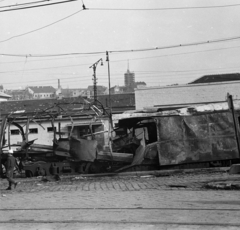 Magyarország, Budapest I., Alkotás utca, a Déli pályaudvarról kitolt, az 1956-os forradalom alatt barikádnak használt vasúti kocsik, fenn a budai Várban a Mátyás-templom felújítás alatt álló tornya látható., 1956, Papp Dezső, járműroncs, Budapest, Fortepan #272750