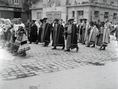 Magyarország, Sopron, Várkerület, a Soproni Dalfüzér jubileumi ünnepségének résztvevői mögött a Húscsarnok látható., 1934, Vargha Zsuzsa, felvonulás, népviselet, pásztor, szűr, Fortepan #273516