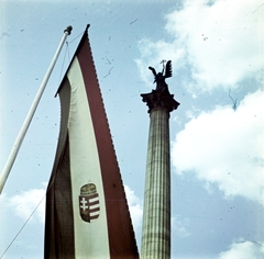 Magyarország, Budapest XIV., a Millenniumi emlékmű közepén a 36 méter magas oszlopon Gábriel arkangyal szobra, melynek egyik kezében a Szent Korona, a másikban az apostoli kettős kereszt., 1942, Koncz Nándor, Budapest, zászló, színes, nemzeti jelkép, Kossuth címer, zászlórúd, angyal-ábrázolás, Fortepan #276692