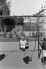 Magyarország, Budapest XIII., Béke tér, játszótér, háttérben a 3-as számú ház., 1957, Obetkó Miklós, kisfiú, árnyék, hinta, Budapest, Fortepan #277161