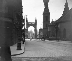 Magyarország, Budapest V., Szabad sajtó (Eskü) út a Váci utca sarkáról nézve. Balra az Osztálysorsjáték palota, jobbra a Belvárosi templom. Az Erzsébet híd hídfőjénél készül a május 1-i dekoráció., 1919, Schoch Frigyes, templom, zászló, utcakép, lámpaoszlop, címer, hídfő, kockakő, Tanácsköztársaság, eklektikus építészet, Budapest, függőhíd, Duna-híd, Kherndl Antal-terv, Czekelius Aurél-terv, Fortepan #27910