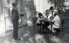 Spanyolország, Lekeitio, Habsburg Ottó az Uribarren-palota teraszán testvéreit fényképezi. Az asztalnál Félix, Károly Lajos, Róbert és Etelka malmot játszanak., 1925, Habsburg Ottó Alapítvány, gyerekek, matrózblúz, fonott szék, fotózás, fotóállvány, gyerekmunka, Fortepan #281184